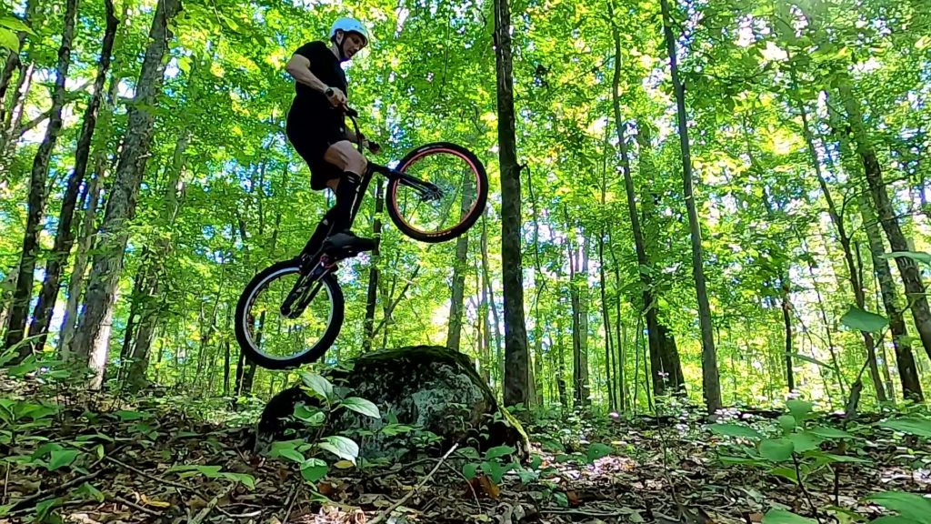 On my trials bike, trying to hop up a sloped rock on my rear wheel
