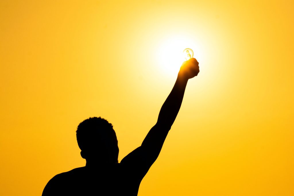 Man holding up a glowing lightbulb