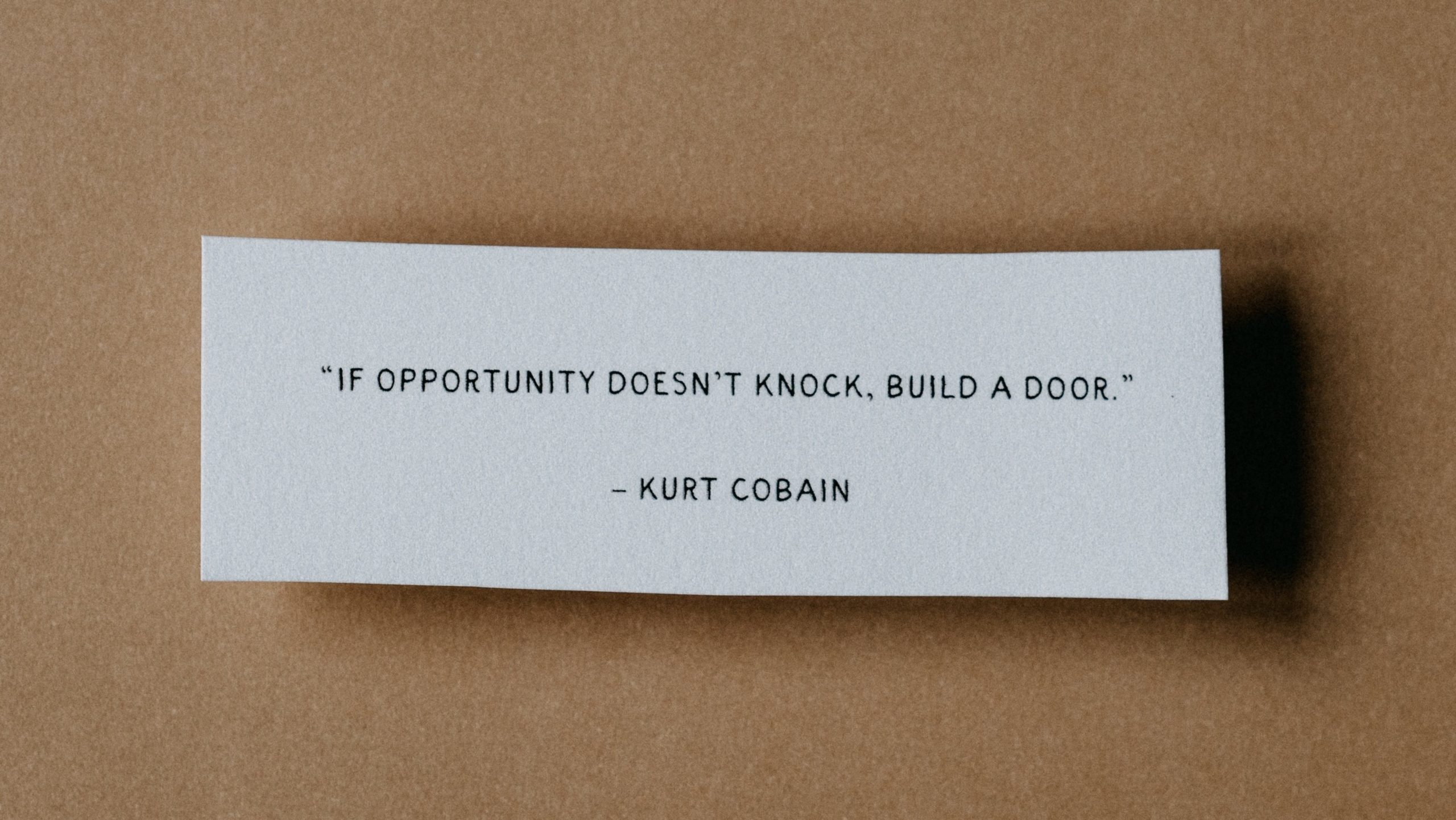 Card that states, "If opportunity doesn't knock, build a door." - Kurt Cobain